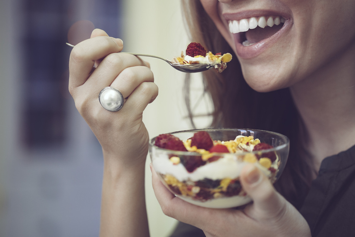 Woman eating cereal, causing foamy saliva