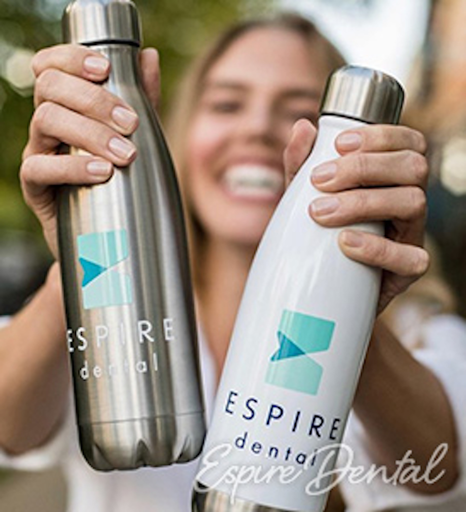 smiling woman holding up two espire branded water bottles