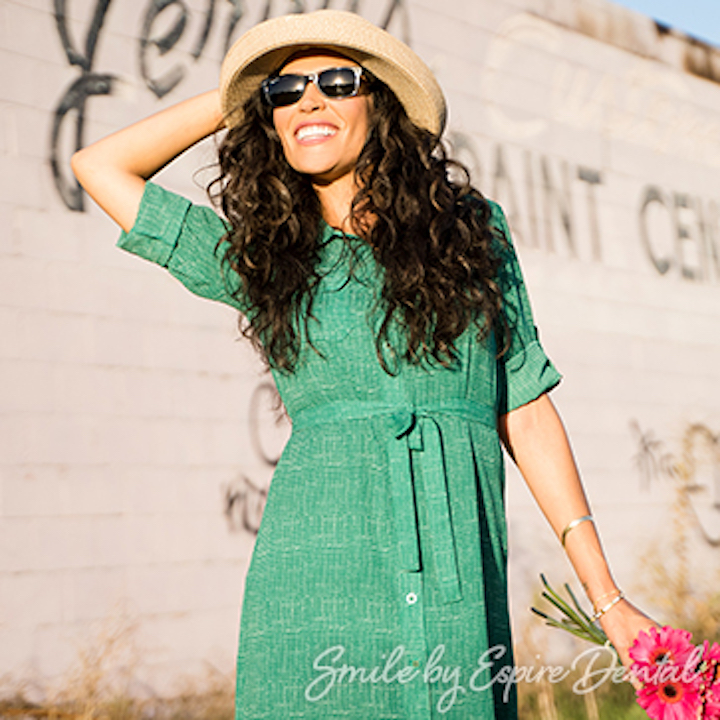 woman in green dress and sun hat smiling