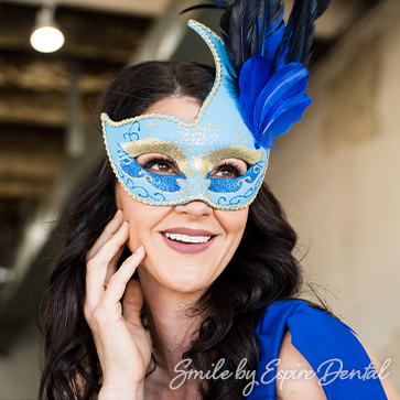 woman in blue shirt with matching blue mardi gras mask