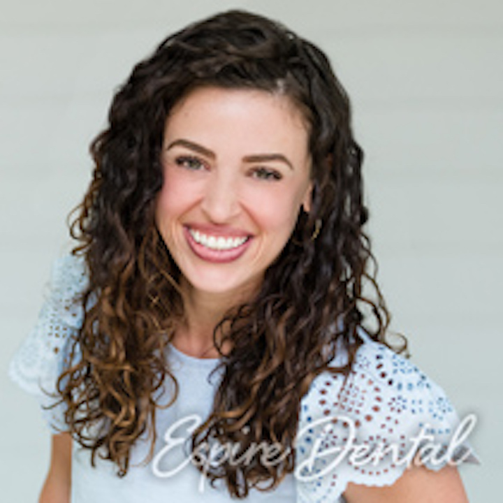woman with brown curly hair smiling